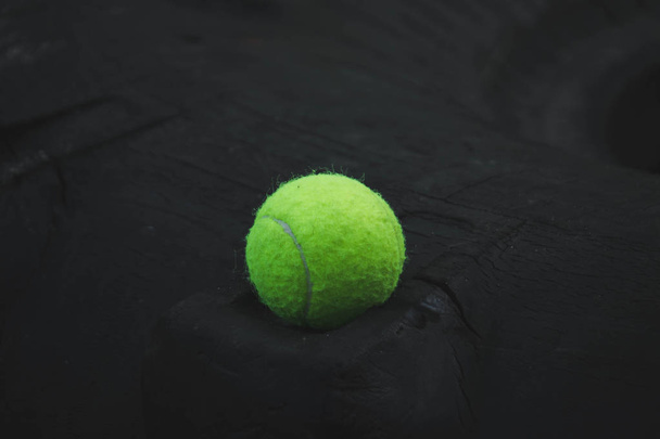 piłka tenisowa leżąca na kole gumowym na boisku sportowym - Zdjęcie, obraz