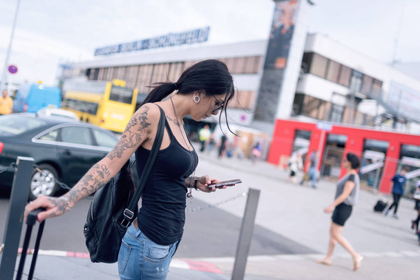 Young brunette tattooed woman portrait at the airport in Berlin, - Fotoğraf, Görsel