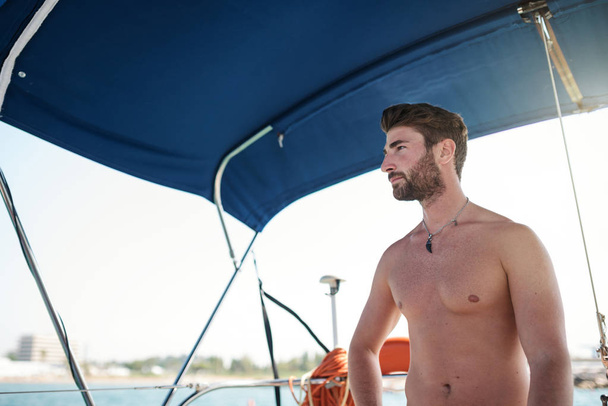Confident young man portrait on sailing boat. - Foto, afbeelding