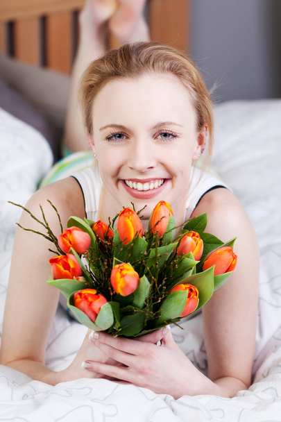Woman Holding Bunch Of Tulips In Bed - Фото, изображение