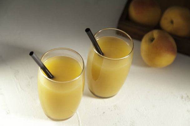 two peach juice glasses on white from above - Photo, Image