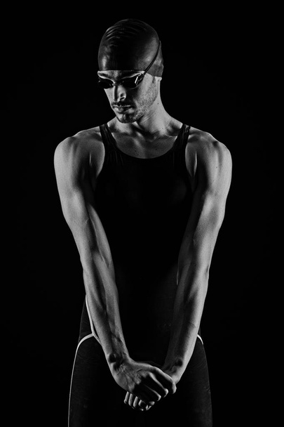 Professional athlete swimmer studio portrait against black background. Black and white image. - Foto, imagen