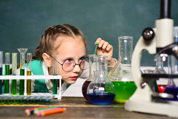 Back to school and home schooling. Science and education concept. Happy little scientist making experiment with test tube. Portrair close up. - Foto, Imagem