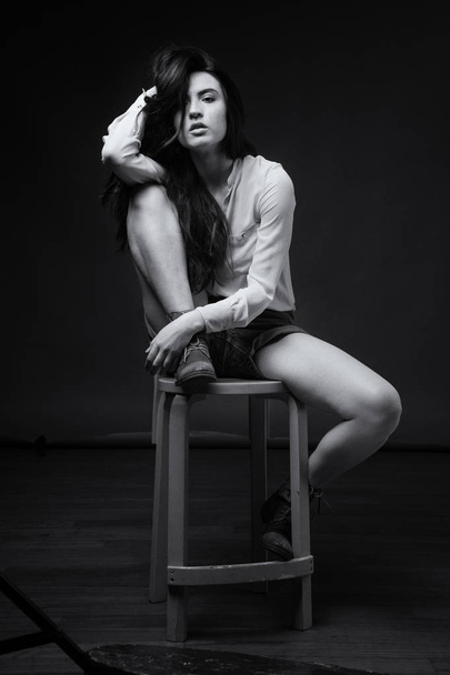 Beautiful intimate young woman full body studio portrait sit on  - Zdjęcie, obraz