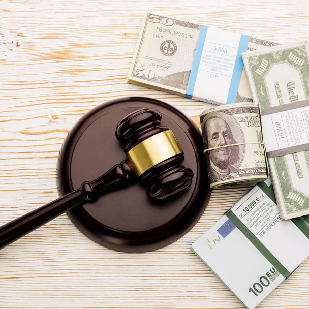 Vue du dessus Marteau du juge et paquets de dollars et billets en euros sur une table en bois blanc
 - Photo, image