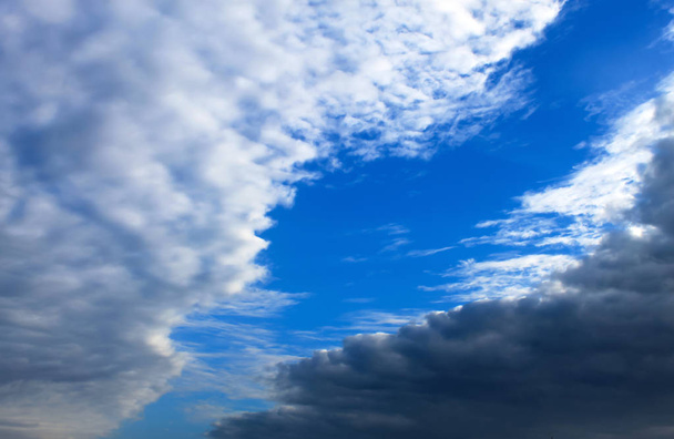 schöne weiße und dunkle Wolken, Regen, Kumuluswolken vor blauem Himmel. malerische, fantastische Wolken. Ebene Landschaft Hintergrund, Sommer, Frühling Plakat. - Foto, Bild