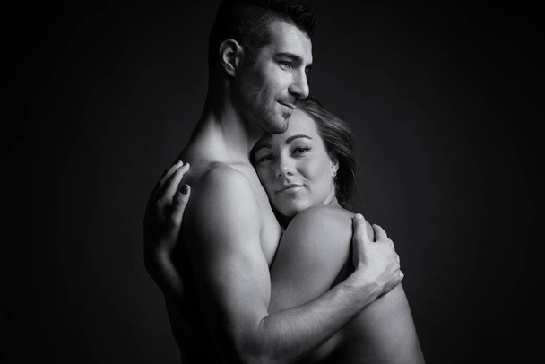 Couple studio intimate portrait. Man and woman hugging. Black and white image.  - Photo, Image