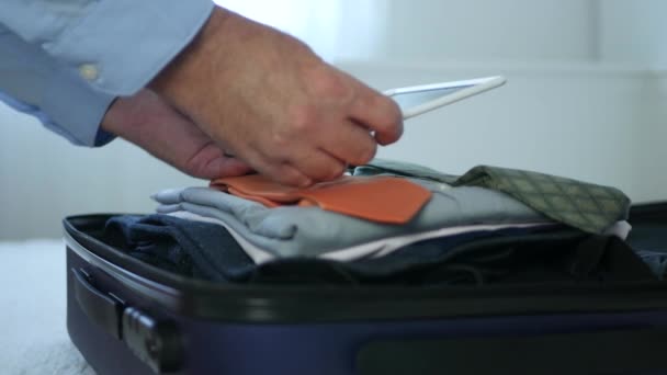 Businessman Preparing for a Travel Check Suitcase Content Using a Touch Tablet - Filmagem, Vídeo