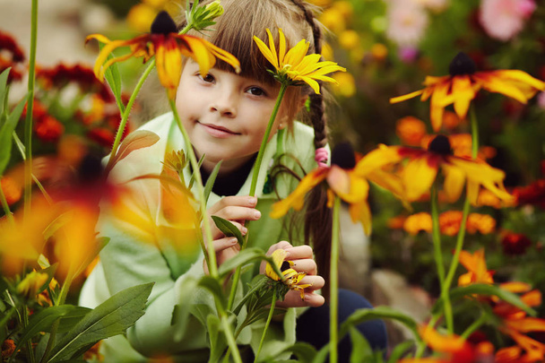 cute little girl in the garden with flowers - Fotografie, Obrázek