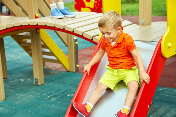 little boy on playground. playing child on slide - Фото, изображение