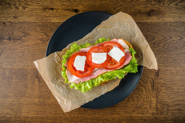Lahodné sendvičové a ležák na dřevěném stole s tmavým zadním - Fotografie, Obrázek