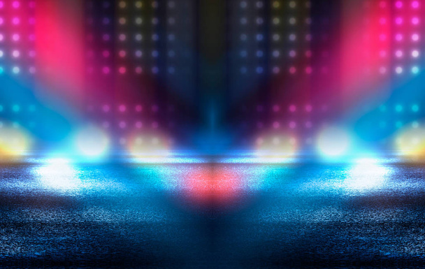 Dark empty stage, multicolored rays of neon searchlight, wet asphalt, smoke, night shooting, bokeh color. - Photo, Image