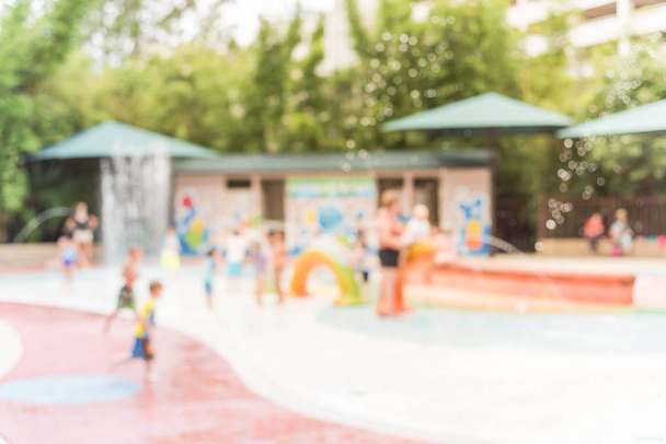 Размытый фон Разнообразные дети играют на водяной площадке в Хьюстоне, штат Техас
 - Фото, изображение