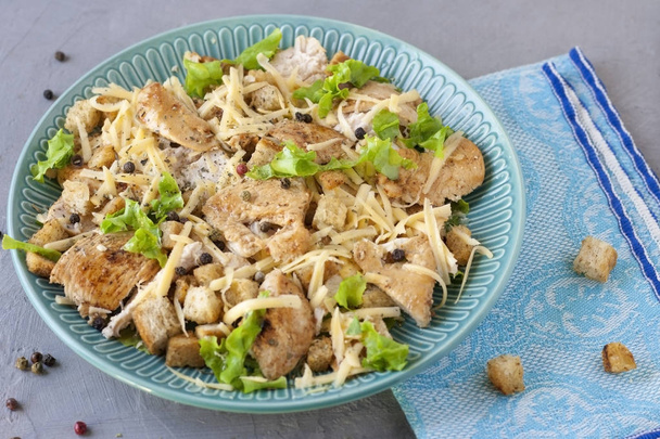 Delicious salad with chicken and crackers on a plate. Caesar salad. - Photo, Image