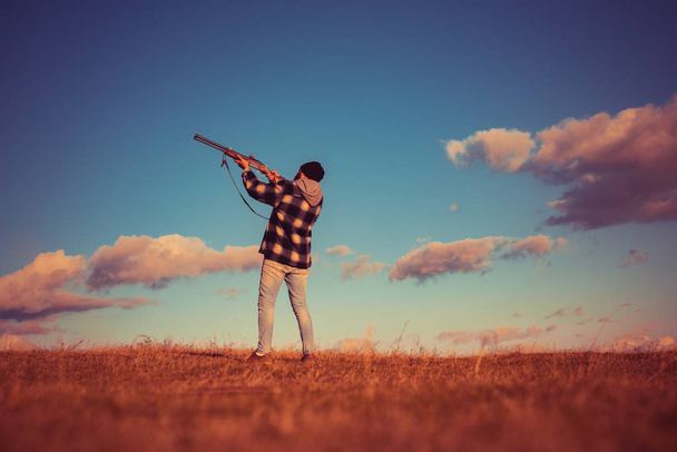 Skeet shooting. Hunter aiming rifle in forest. Hunter with shotgun gun on hunt. Hunting without borders. Process of duck hunting. Copy space for text. - Photo, image