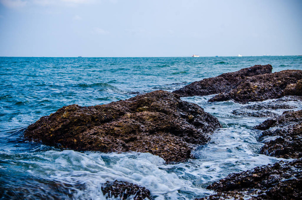 Ocean waves breaking on the rocks on the shore. - Фото, изображение