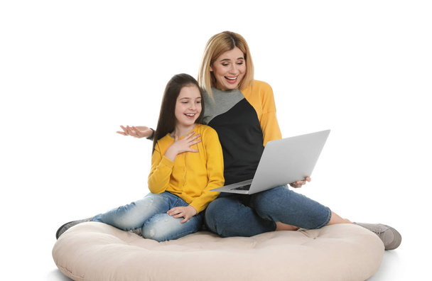 Mãe e sua filha usando vídeo chat no laptop contra fundo branco
 - Foto, Imagem
