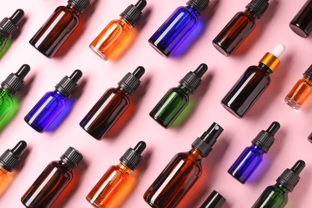 Bottles of essential oils on color background, flat lay. Cosmetic products - Φωτογραφία, εικόνα