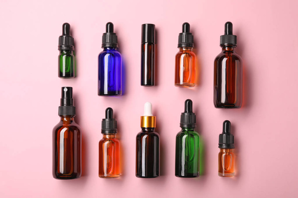 Bottles of essential oils on color background, flat lay. Cosmetic products - Photo, Image