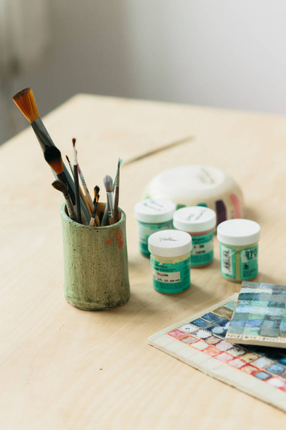 Potter holds the color palette glazes for coating ceramic products - Valokuva, kuva
