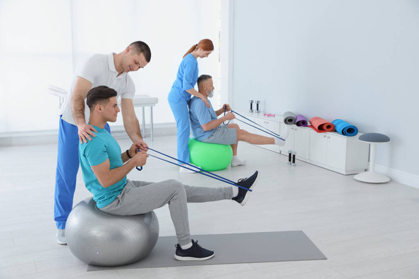 Professional physiotherapists working with patients in rehabilitation center - Fotografie, Obrázek