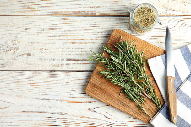 Flat lay composition with fresh rosemary twigs on wooden table. Space for text - Foto, Imagem