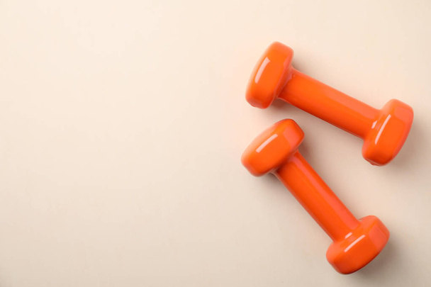 Bright dumbbells and space for text on color background, flat lay. Home fitness - 写真・画像
