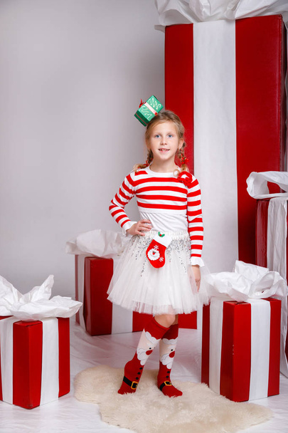 Забавная маленькая девочка в новогоднем образе, проявляющая разные эмоции. Фото сделано в студии
 - Фото, изображение