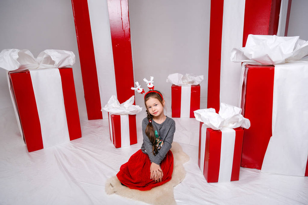 Funny little girl in the New Year's image, showing different emotions. Photo taken in studio - Photo, Image