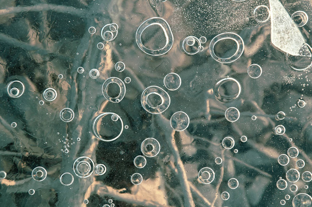 Tekstura abstrakcyjna lód tło z bąbelkami powietrza złowionych przez mróz w masie wody podczas zamrażania - Zdjęcie, obraz