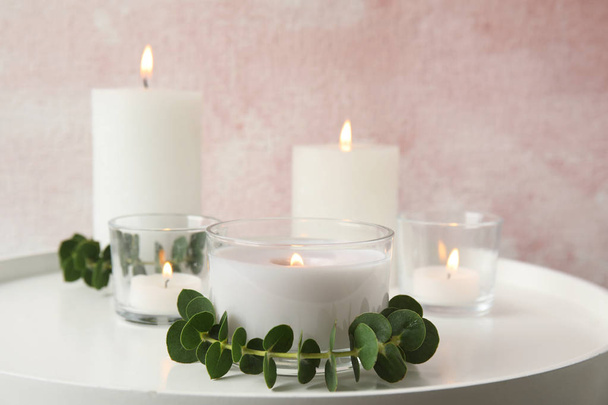 Composition with burning aromatic candles and eucalyptus on table. Space for text - Photo, Image