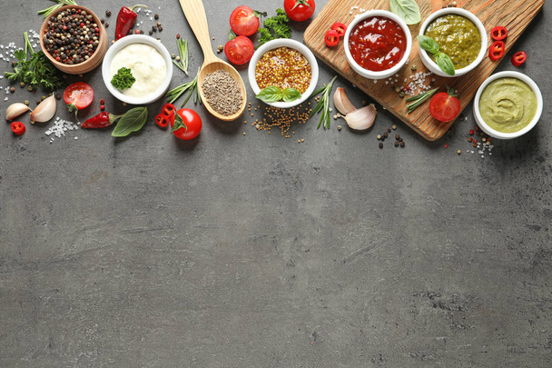 Flat lay composition with different sauces and space for text on gray background - Foto, afbeelding
