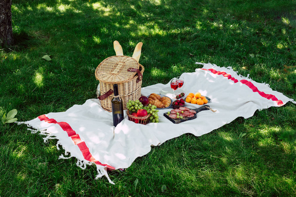 Piknikkori, hedelmiä ja viiniä, kesäpäivä puistossa
 - Valokuva, kuva