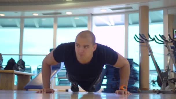 Jonge atletische man maakt push-ups oefening in de sportschool - Video