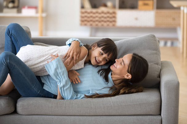 Happy mom and little daughter relax having fun on couch - Photo, Image