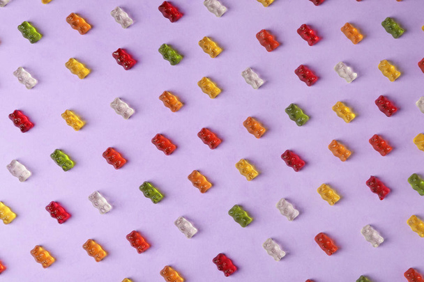 Плоска композиція з смачними ведмедями желе на кольоровому фоні
 - Фото, зображення