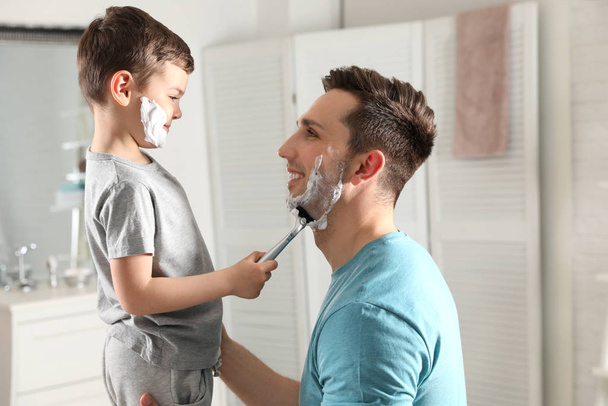 Little son shaving his dad in bathroom - Photo, image