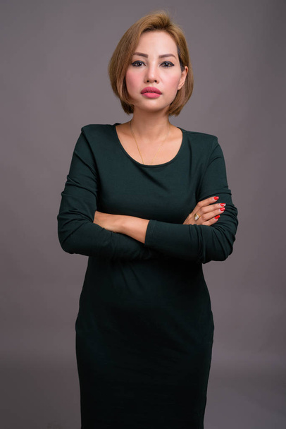 Studio shot of beautiful Asian businesswoman against gray background - Foto, Imagem