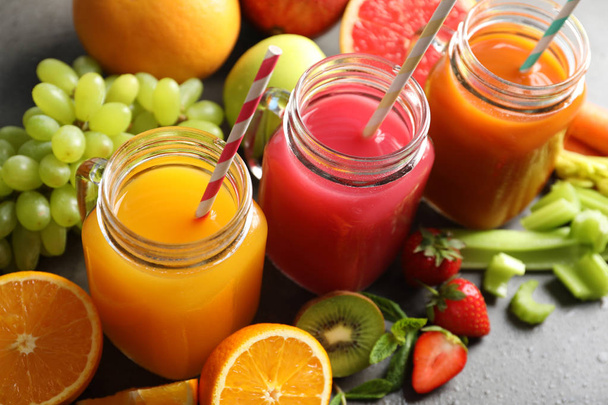 Different juices in mason jars and fresh ingredients on grey table - Photo, Image