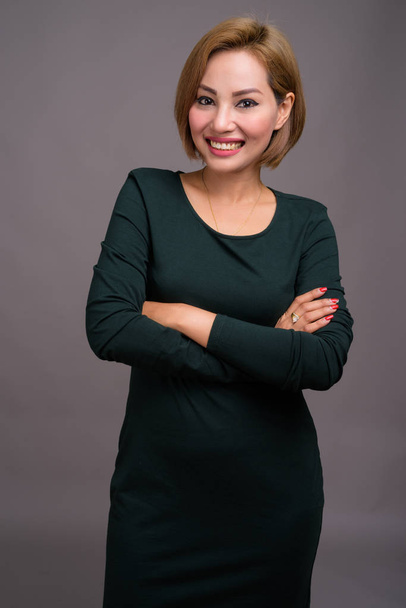 Studio shot of beautiful Asian businesswoman against gray background - Фото, зображення