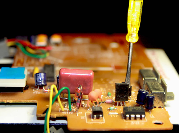 Carte électrique avec composants électroniques. Carte de circuit imprimé high-tech. Tournevis
. - Photo, image