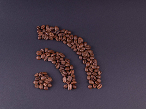 Sign wi fi laid out coffee grains on a dark background - Φωτογραφία, εικόνα