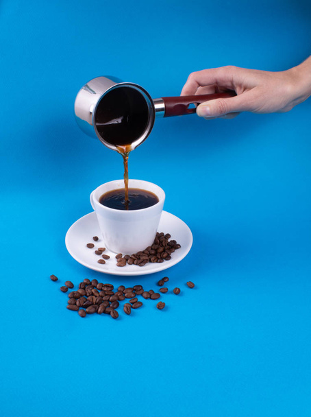 Рука наливає каву в чашку з посудини
 - Фото, зображення