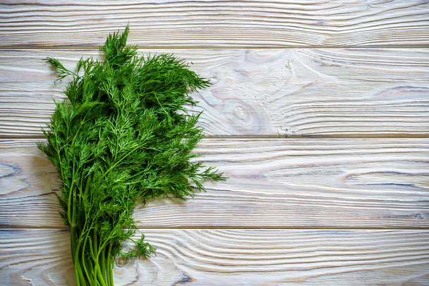Bunch of dill isolated on a wooden background with space for tex - Photo, Image