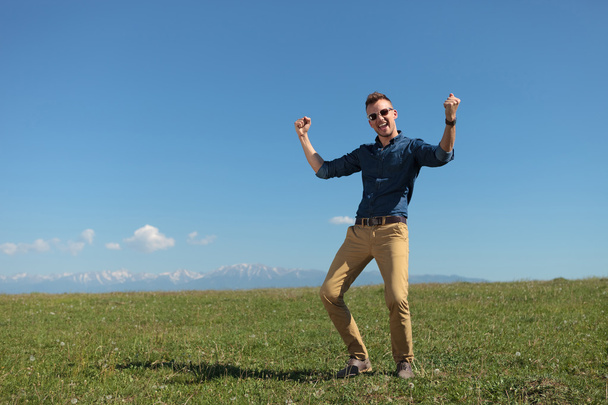 homme occasionnel en plein air acclamations sur une plaine verte
 - Photo, image