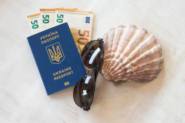 Reizen en vakanties in Europa of in het buitenland. Oekraïne paspoort voor reizen in Europa tegen de achtergrond van de euro bankbiljetten. - Foto, afbeelding