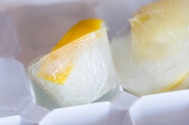 Slice of lemon frozen in a piece of ice - Фото, изображение