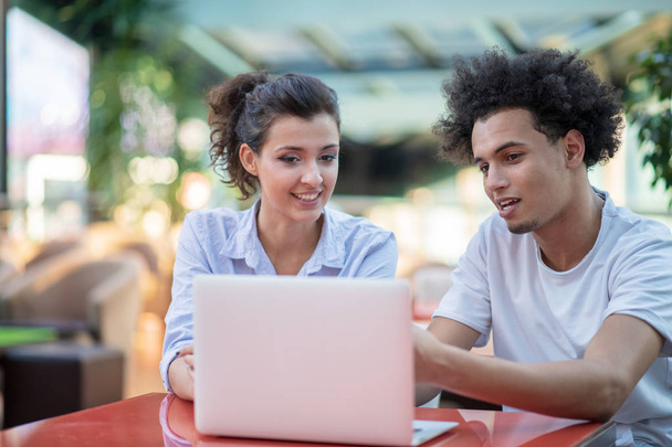 Interracial couple using tablet computer in coffee shop - Фото, изображение