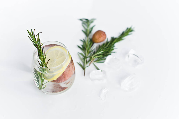 レモン、ローズマリーと透明な水のグラス. - 写真・画像