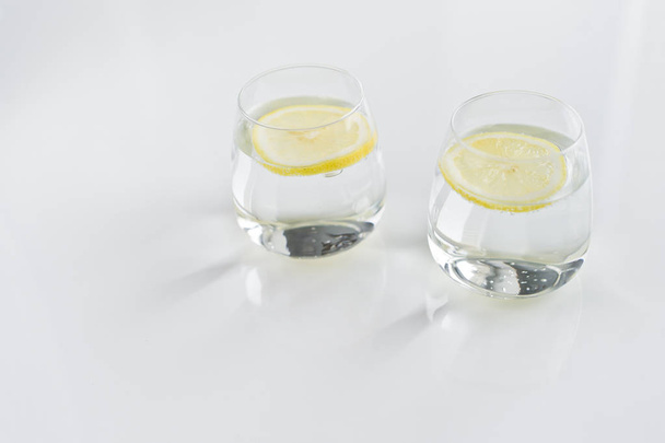 δύο ποτήρια καθαρό νερό με λεμόνι. - Φωτογραφία, εικόνα